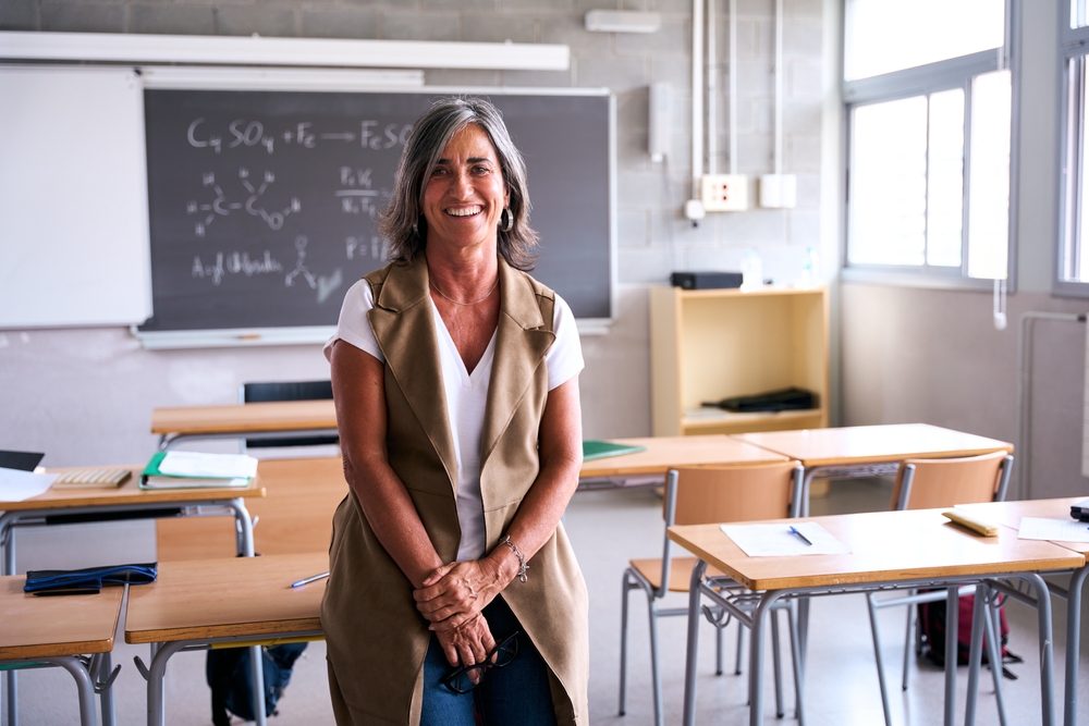 Professora em sala de aula organizada, representando os primeiros passos de como abrir uma escola particular.