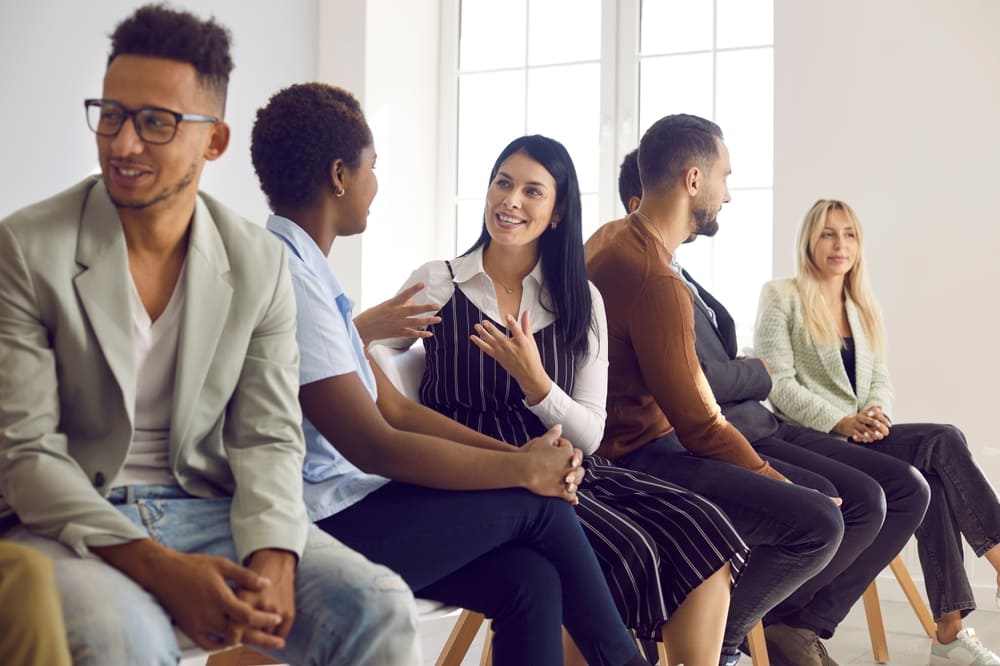 Grupo de pessoas praticando inglês em uma conversa ao vivo, utilizando o conceito de "speak to speak".