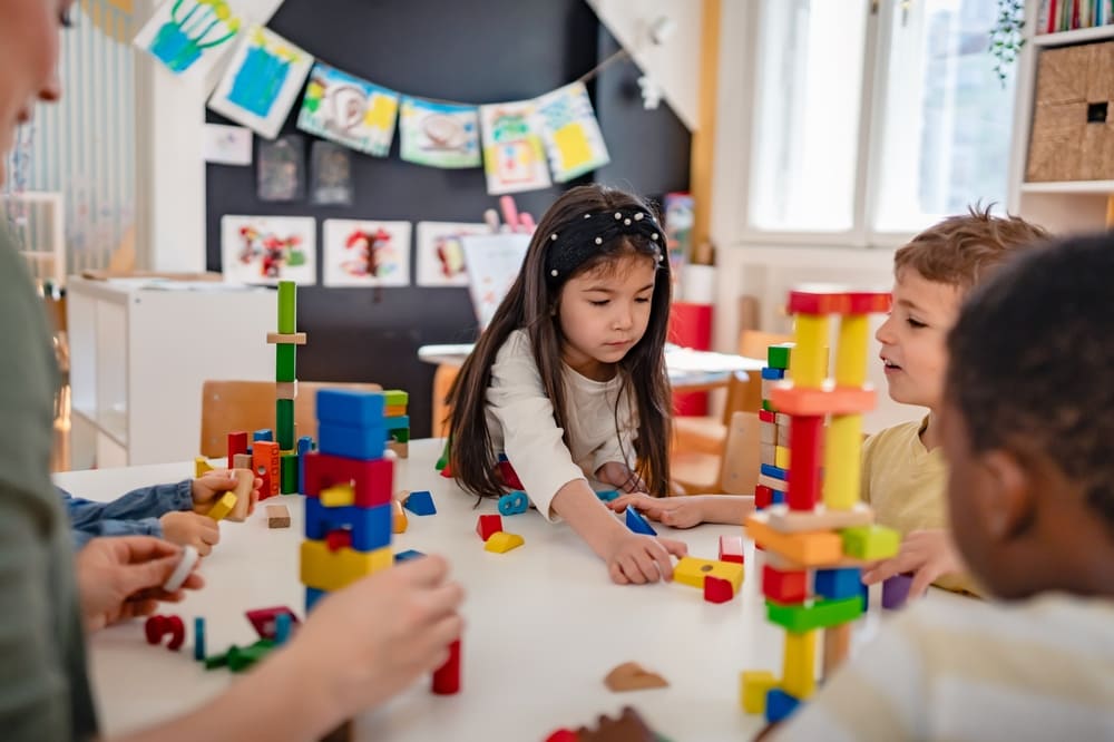 Crianças montam blocos coloridos na Educação Infantil, abordagens pedagógicas ativas e investigativas.