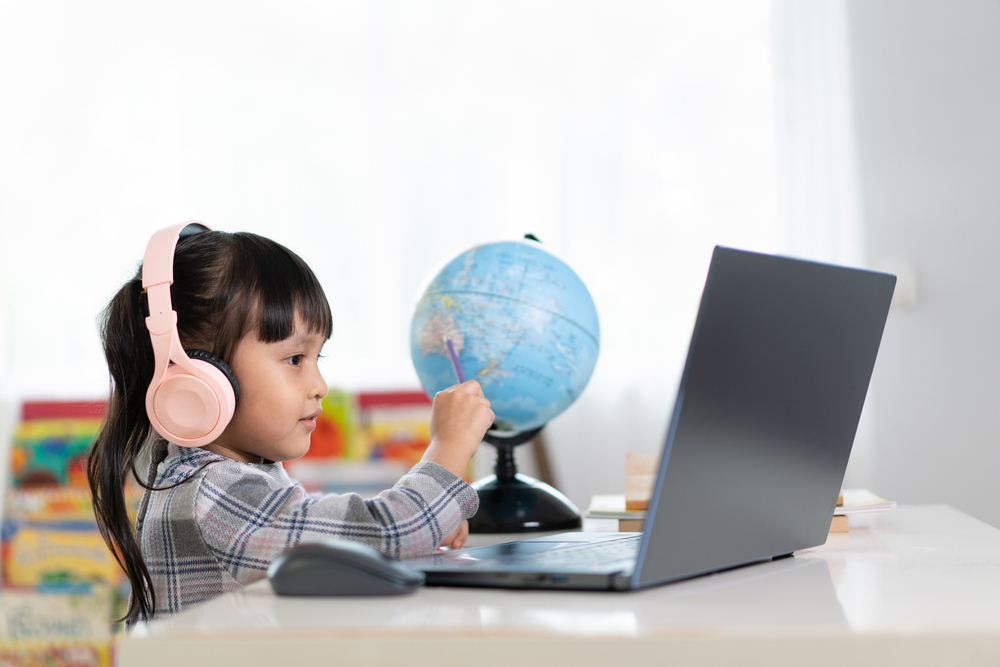 Aluna estudando em sala de aula de escola bilíngue.