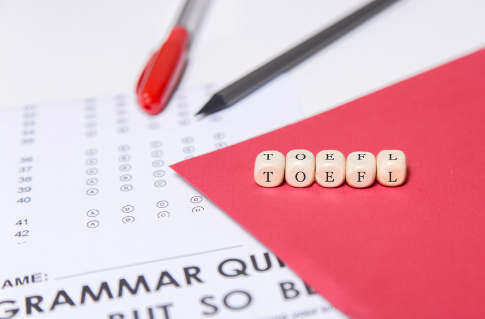 Preparação para o TOEFL com folha de teste em inglês sobre a mesa.